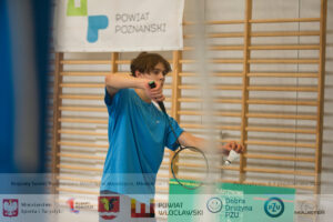 Chłopiec w niebieskiej koszulce grający w badmintona