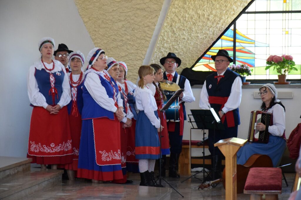 Grupa ludzi ubranych w stroje ludowe w Kościele